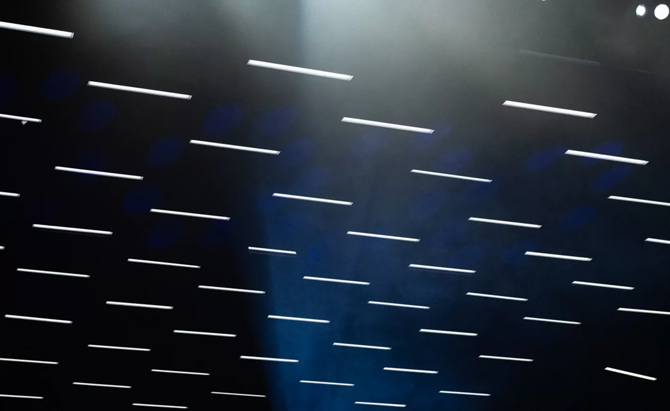 Motif géométrique de lumières LED au plafond créant une ambiance scénographique lors d'un événement produit par l'agence gcom fin 2025.